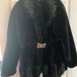 Black fur coat size 16 with gold metal belt buckle pickets extra fur round the neck cuffs and bottom of the coat hooks and eyes down the front of the coat I brought it for £35 hardly wore it don’t fit me now that’s why I’m selling it