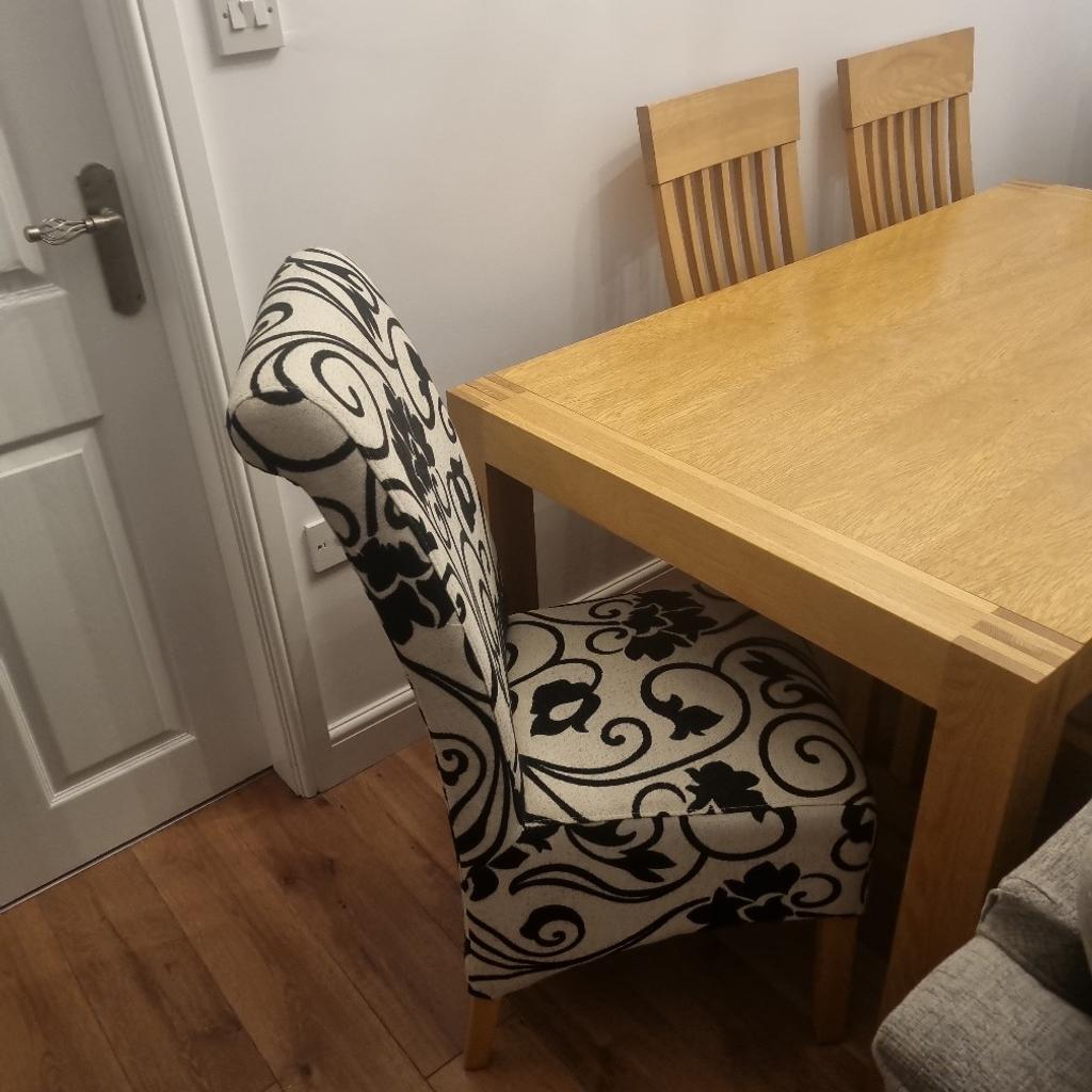solid oak table .extends. cost over thousand pounds from Nettletons . 4 oak chairs plus 2 cream and black chairs .excellent condition well looked after . buyer to dismantle.