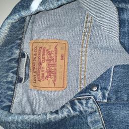 Levi's Authorized Vintage Trucker Jacket Men XL Blue Denim. 

This item is being tried on and not being worn out or washed. Practically new. 

One-of-a-kind, authentically vintage trucker jacket.

Original paper patch with size stamped in red. Original vintage Levis trucker jacket 70503, made in the UK, produced in the early 2000s. In perfect condition, light blue color (stonewash) might have some cosmetic imperfections due to storage . There are 2 chest pockets on the front, 2 on the bottom and 2 inside pockets