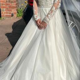 A beautiful Ivory wedding dress. Classy and elegant with lace detailing at the top and satin bottom covered with an Italian tulle fabric. Puffy bottom half gives it the princess look.

Silver diamanté waiste lining.

Extremely light making it very easy to walk in.

Designer - Grace Ellis.

Size - 6/8

Worn for a few hours.

RRP £900