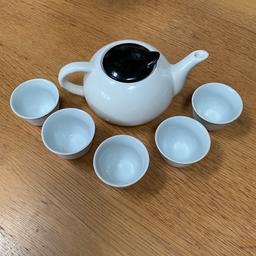 Small white teapot with black lid and five small glasses with gold design. Very quirky and rarely used so selling to someone who will make use of it or for play/show/props etc. Teapot slightly chipped near one side of spout but all else very good. Can deliver or post for extra.