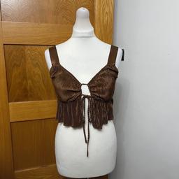New with tags, size 8, colour brown, RRP £24

Adding instant summer vibes to your collection, this cropped cami top has been crafted from a a lightweight polyester fabrication whilst the ruffled detailing adds a flattering fit. Cut with a v-neckline falling into a tie-closure, this cami offers non-adjustable shoulder straps. Pair yours with denim shorts and sliders whilst strolling down the beach front.

Cropped
Regular fit
Sleeveless
V neck
Pullover
Tie front

Material: 100% Polyester

Stock photos can be shown, please just ask

#ladiescroptop #ladiesbratop #bratop #croptop #missguided