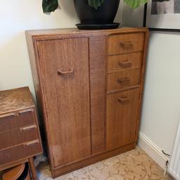 Fantastic vintage G Plan mid century tallboy for clothes and storage. One large space for hanging clothes with 3 small draws. The top with a pullout mirror and jewelry box. Another taller space for more storage. The split on the second draw was how we bought it and as seen on the pictures it does have some marks.

Dimensions
88w
46d
122h