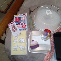 Baking bundle includes, apron, loaf tin, 2 cake containers, tin of piping bags and nozzles, jar of birthday candles, cake slicer, whisk, box of cupcake cases, Jane asher animal plunge cookie cutters, some new, some used but in really good condition