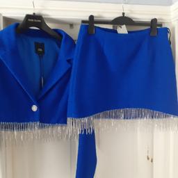 Brand New. Royal Blue Crop Jacket and skirt suit from River Island. Jacket size 12, Skirt size 14, skirt size comes up small. Reinstone tassels.
