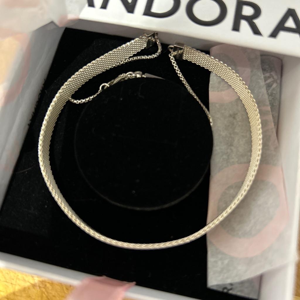 Add an element of unorthodox style and a rebellious twist to any outfit with this adjustable choker necklace. This Pandora Reflexionsâ„¢ flat choker in sterling silver mesh can be worn alone or with up to 12 Pandora Reflexionsâ„¢ charms to show off your unique personality. The adjustable sliding clasp quickly and easily adjusts the choker to fit perfectly around your neck to create a look like no other.

Unwanted present by my Daughter.
Paid over £150 !

New and in original box.
