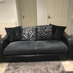 Black three seater DFS sofa with cushions. Black leather look with grey velvet type material seating and additional cushions.
Non smoking home, in good condition.