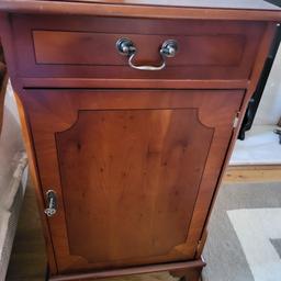 a yew wooden hallway cabinet with top drawer and a shelf inside door with key lock in good condition for its age.