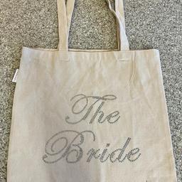 Great condition

Varsity ‘The Bride’  Tote Bag Made with Rhinestone Crystals - Bride Tote Bag Made of Cotton - Team Bride Bags Best Suited to be Used as Bride to be Gifts -
Ivory with silver Rhinestones 
Care instructions
Hand Wash Only
Country of origin
United Kingdom
Size 37cm x 37cm not including the handles