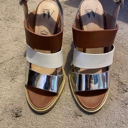Tan, white and silver block heel sandals. Great condition with a mark on back if one heel as seen in photo.