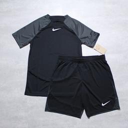 Elevate your activewear game with this sleek and stylish Nike Dri-fit Academy top and short set. Designed for men, this tracksuit is perfect for sports enthusiasts who want to look good while staying comfortable. The set includes high-quality knit fabric that feels soft against the skin and comes in a timeless black colour that pairs well with anything. This Nike tracksuit is perfect for any occasion, whether you're hitting the gym or going for a run. The set includes an Academy top in size small and shorts in size medium, both of which have been crafted with the utmost care and attention to detail. With the Nike logo stamped on the front, this tracksuit is a must-have for any sports fan who wants to make a statement.