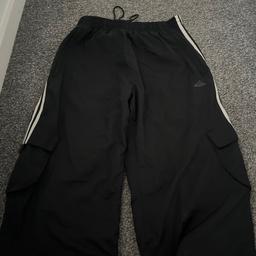 Adidas 3/4 shell material type joggers.
UK Medium with elasticated waist, with pull cords at leg
4 pockets;- 2 side zip and 2 press stud at each knee
There is a click in the stitches in the logo however