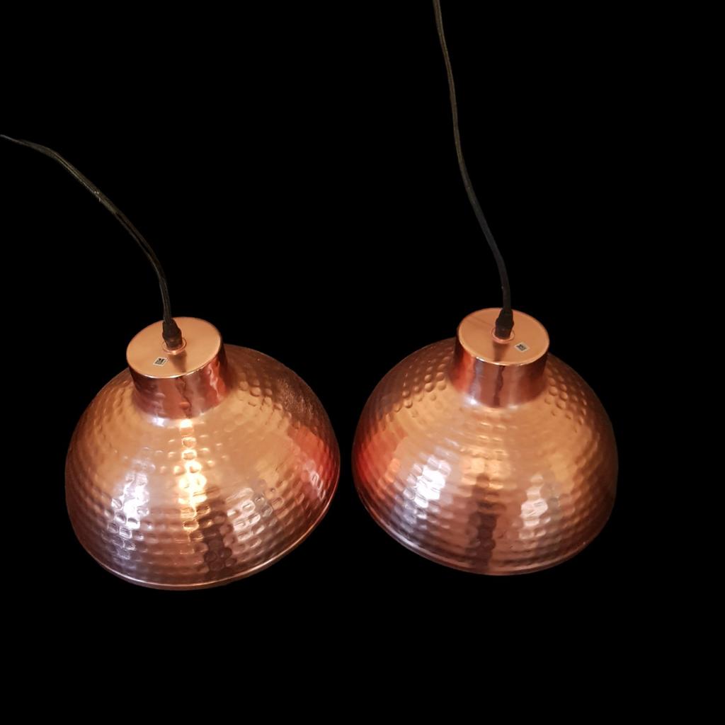A stunning pair of hammered copper light pendants.