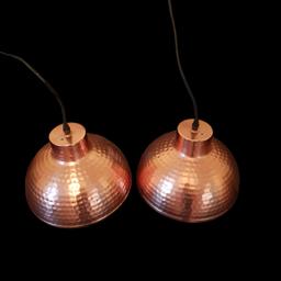 A stunning pair of hammered copper light pendants.