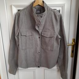 Ladies short grey jacket from Next. Size 14 with 2 front pockets, front zip fastening with press studs and a frayed hem. Excellent condition, never worn.