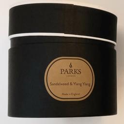 A Parks large candle with three wicks. It is made with natural wax and has a sandalwood and ylang ylang scent. New.