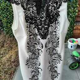 Weißes Abendkleid mit schwarzem Muster und Schleife dazu.
