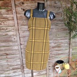 Primark size 14 pinafore mini dress. Mustard yellow and black check. Stretchy fabric. Square neckline. 
Chest measures 32"
Length 35.5"
96% polyester 4% elastene