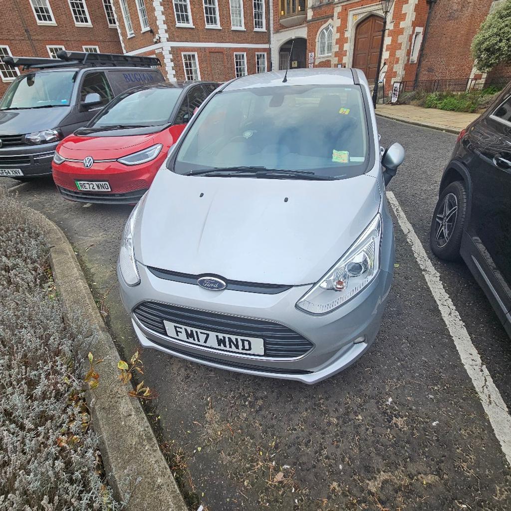 For sale is a Ford B-Max Titanium Navigator, registered in July 2017 with a mileage of 72460. This 5-door MPV has a 1.0 EcoBoost engine and is ULEZ compliant. It has had 2 previous owners, with the current being the third. The MOT expires on 28 January 2025 and it is Euro 6 emission class. The exterior and interior colours are both silver and grey respectively. This car has manual transmission and is right-hand drive. It is a petrol-fuelled passenger vehicle that can seat up to 5 people.