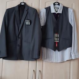BOYS 5 PIECE GREY SUIT BY FLIPBACK.

SUIT: 88% POLYESTER, 12% VISCOSE, LINING: 100% POLYESTER.

JACKET: AGE 13 YEARS. CHEST 32", HEIGHT 160 CM.
2 INSIDE POCKETS. 3 FRONT POCKETS INCLUDING 1 BREAST POCKET AND 4 BUTTONS ON CUFFS.

TROUSER: AGE 13 YEARS. WAIST 30", HEIGHT 160CM.
2 SIDE POCKETS, 1 BACK POCKET WITH BUTTON FASTENING.

WAISTCOAT: AGE 13 YEARS. HEIGHT 160CM.
2 FRONT POCKETS.
BUTTON FASTENING.

STRIPED SHIRT. AGE 13-14 YEARS. HEIGHT 160-168 CM.
60% COTTON, 40% POLYESTER.
COLOUR: PURPLE/WHITE.

PURPLE TIE. 100% POLYESTER.

ALL ITEMS SOLD AS A BUNDLE.

UNUSED. AS NEW CONDITION.

COLLECTION ONLY.