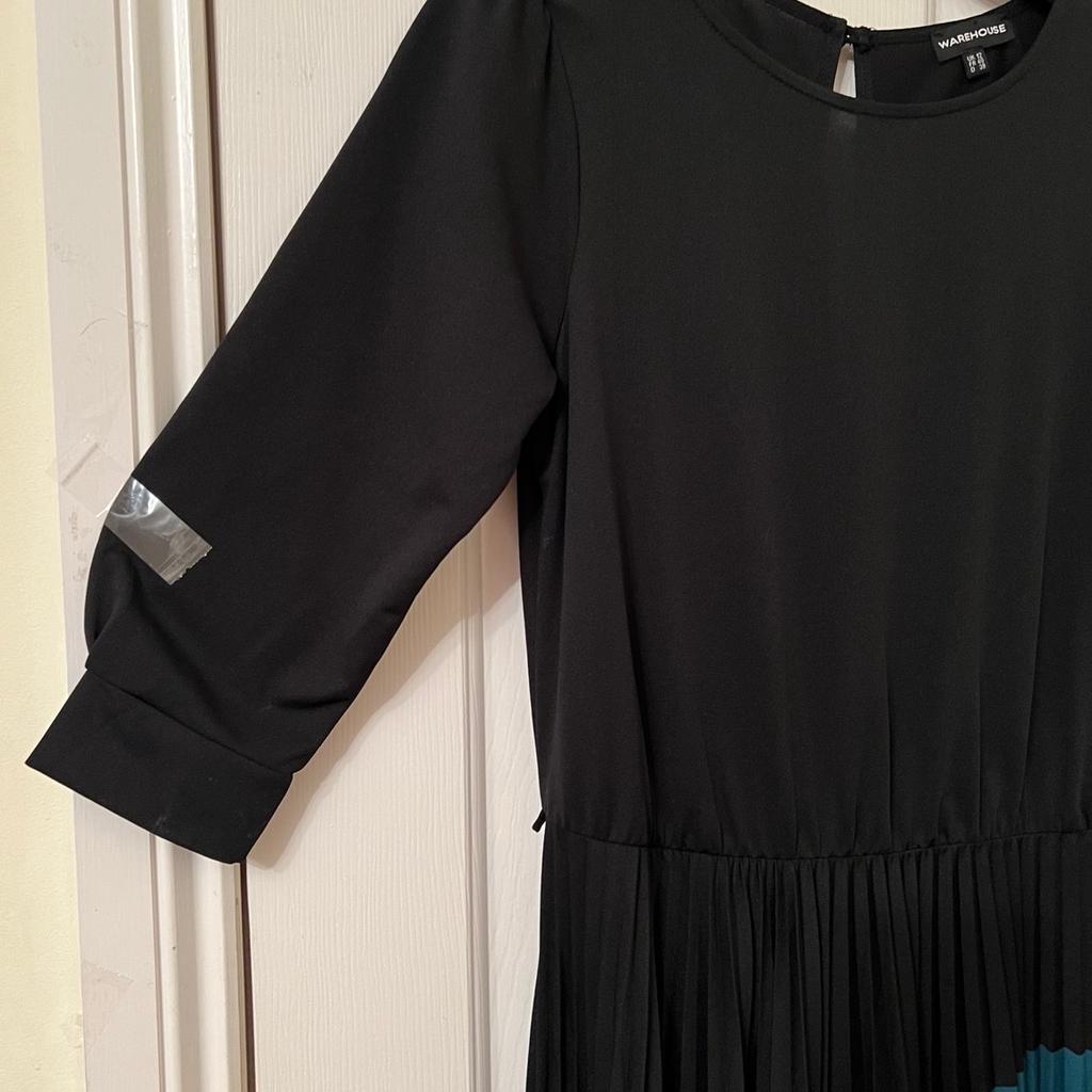 Lovely soft stretchy comfy fabric.black with jade green colour at the bottom.fasterns at the back of the neck with 1 button.elasticated waistband.size 12 from Warehouse.in very good condition.oworn once for a special occasion