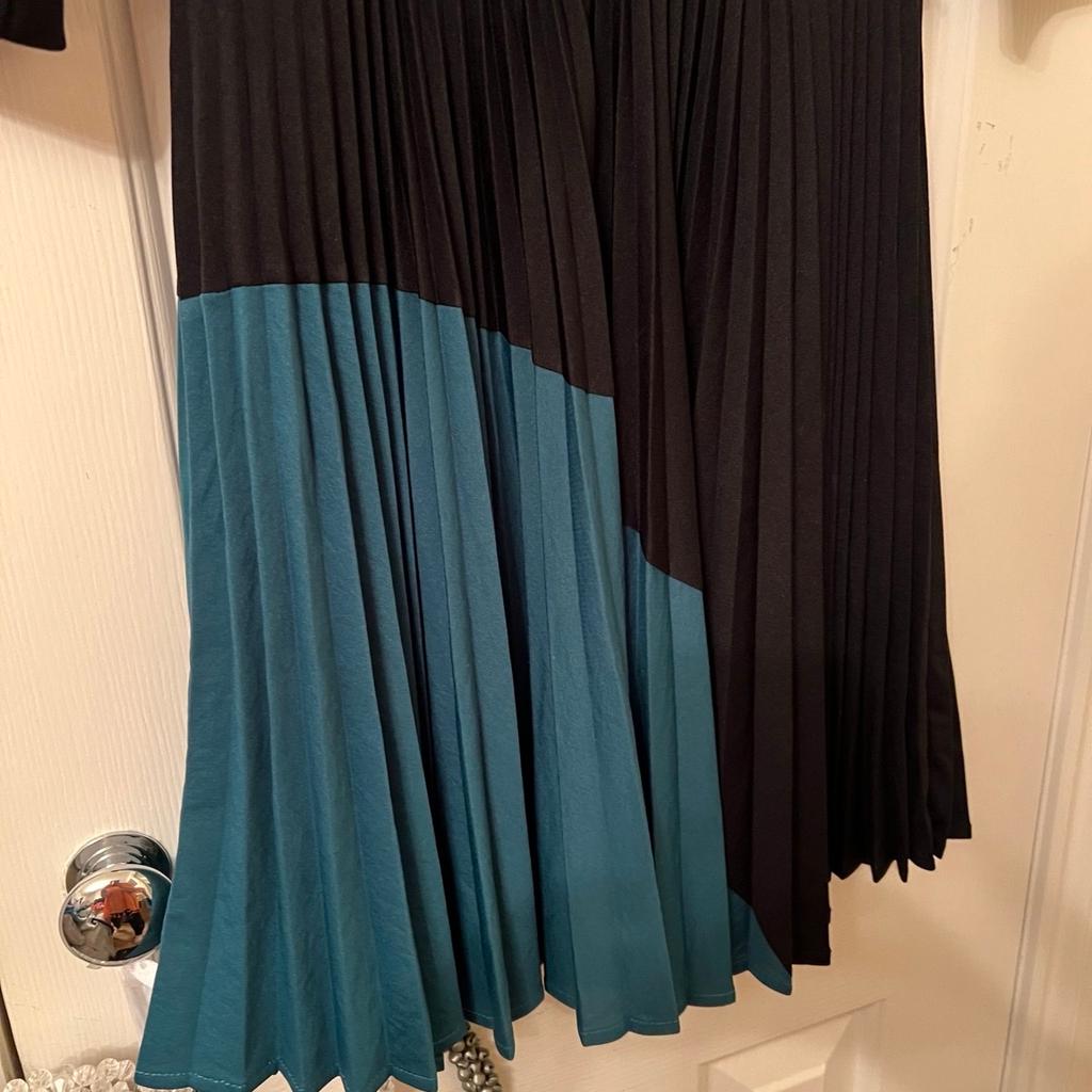 Lovely soft stretchy comfy fabric.black with jade green colour at the bottom.fasterns at the back of the neck with 1 button.elasticated waistband.size 12 from Warehouse.in very good condition.oworn once for a special occasion