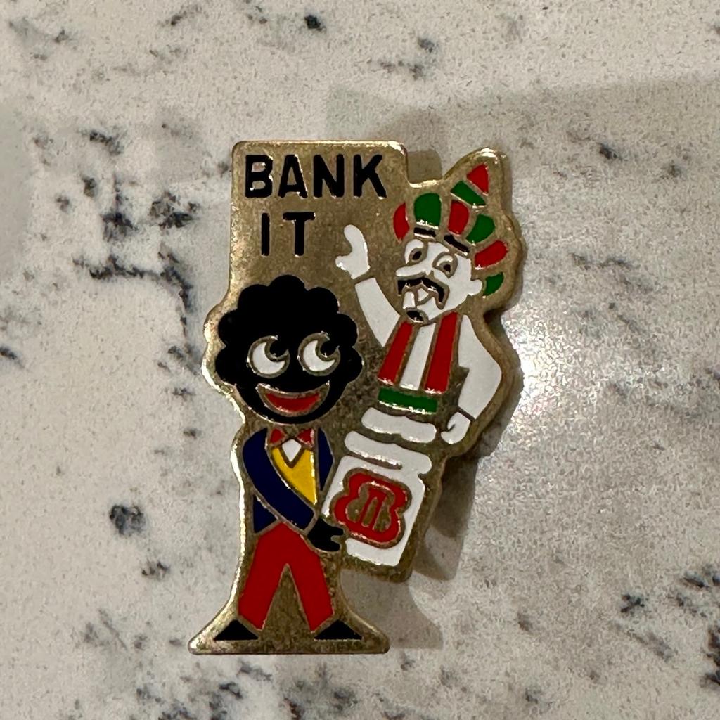 A scarce original circa 1982 'Robertson's Golly special promotions 'Bank It' badge', depicting a Genie in a bottle, the reverse correctly unnamed as issued. Very good condition, complete with original pin fittings complete, safety roller catch in good working order, painted enamel finish intact.