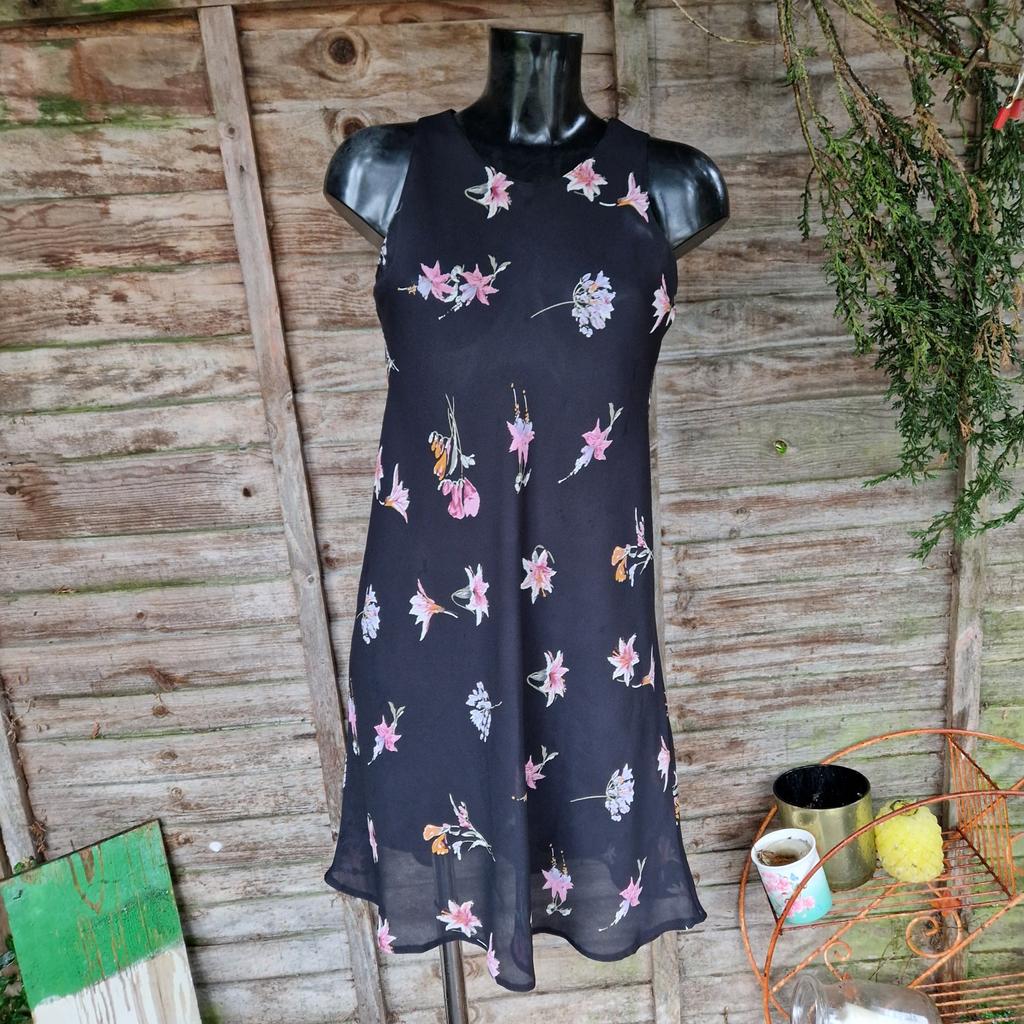 Vintage 1990s Topshop dress. Bias cut. Sheer black with pastel flowers. Flippy skirt. Sleeveless. Round high neck.
Label states size 14.
Chest measures 38"
Waist measures 44"
Approx size 10 12
Faint deodorant marks under arms.
