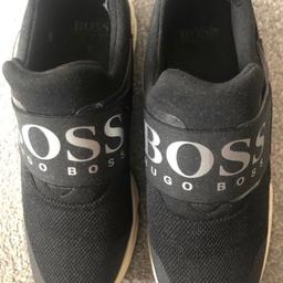 Elevate your little boy's shoe game with these sleek Hugo Boss trainers in a classic black colourway. Crafted with high-quality materials, these sneakers feature a comfortable fit that will keep your child's feet happy all day long. Perfect for any occasion, the trainer's versatile design makes them suitable for both casual and formal wear.

The Boss brand is renowned for their premium quality products, and these boys' trainers are no exception. With a UK shoe size of 6 and a stylish sneaker silhouette, they're a must-have addition to any young fashionista's shoe collection.