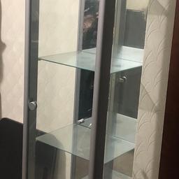 168cms high and 35cms wide. Silver glass display cabinet. 4 shelves. Door opens. Light with bulb included on top shelf. Long cable. In very good condition