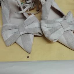 ASOS beige and white shoe with a .bow it has strap to further tie your ankle and calves batgain