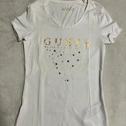 T-Shirt von GUESS mit Goldaufdruck.
Material: 95% Baumwolle, 5% Elasthan
Ungetragen inkl. Etikett