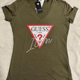 T-Shirt von GUESS in olivgrün mit Steinchen.
Material: 100% Baumwolle
Ungetragen inkl. Etikett