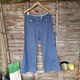 Vintage 1990s Next blue lightweight jeans. Flared leg. Creased centre leg. Contrast stitching. Mid to high rise. Button through flap over front and back pockets. Zip up and double button through strap across waistband. Belt loops. Stretchy. Check fabric inside waistband. Silver metal buttons. 
Label says size 14.
Waist measures 36"
Inside leg measures 30.5"
71% cotton 27% polyester 2% elastene 
Back bottom hems are creased/ scrunched up and wear to edge from wearing them too long and them draggi