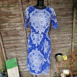 Asos size 12 midi length dress. Cornflower blue and white cut out lace 'tablecloth' stretchy fabric. Scalloped edges. Attached white underskirt. Elasticated waistband. Elbow length sheer sleeves. Low scoop back. 
Chest measures 38"
Waist measures 26"-36"
Length 46"-47"
Few pulls. 
60% nylon 40% polyester