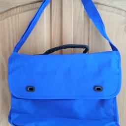 This blue shoulder bag is a must-have for anyone looking for a retro and unique piece. The rare unisex bag features blue solid colour and a button closure, with a strap included. Perfect for school or any casual outing, the medium-sized bag is in excellent shape and ready for use. Its exterior is made of a special material, with a blue exterior and blue lining.