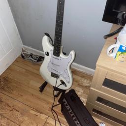 basically brand new, pre tuned and only used a few times, comes with a bag of plectrums and an amp (wires included)