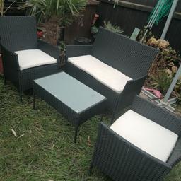 Black rattan set with cream cushions, 2 seater, 3 chairs and glasstop table. Good condition apart from scuff on armrest  corner on one chair, hardly noticeable. Can deliver local for fuel.
