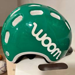 Woom Helm in grün mit gebrausspuren.