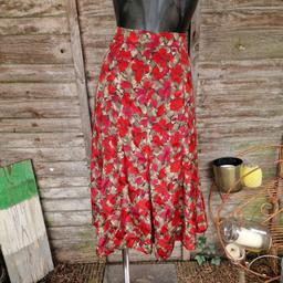 Vintage 1990s handmade midi skirt. Khaki green leaves with flowers in shades of red with black outline. Attached underskirt. Zip and button up back. 
No labels. 
Approximate size 10
Waist measures 30"
Length
Button needs securing.