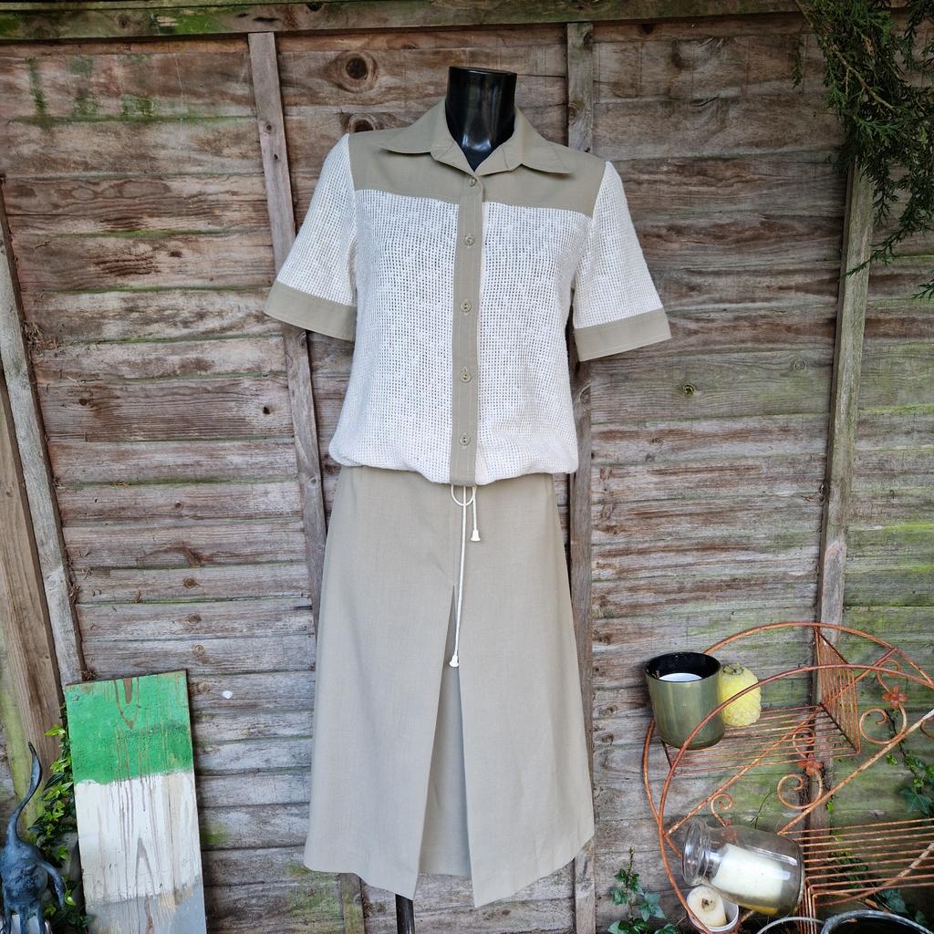 Vintage 1970s St Michael Marks and Spencer skirt and shacket co-ord suit.
Khaki green with cream cut-out lattice grid.

A-line skirt with inverted pleat front. Zip and hook fastening back.
Waist measures 26"
Length 29"

Shirt jacket top. Button up front. Open dagger collared neck. Short sleeves. Pull through cord waistband with toggles.
Chest measures 36"

Label says size 14 approximate size 8 10.
70% polyester 30% viscose
Few minor marks on the cream section.