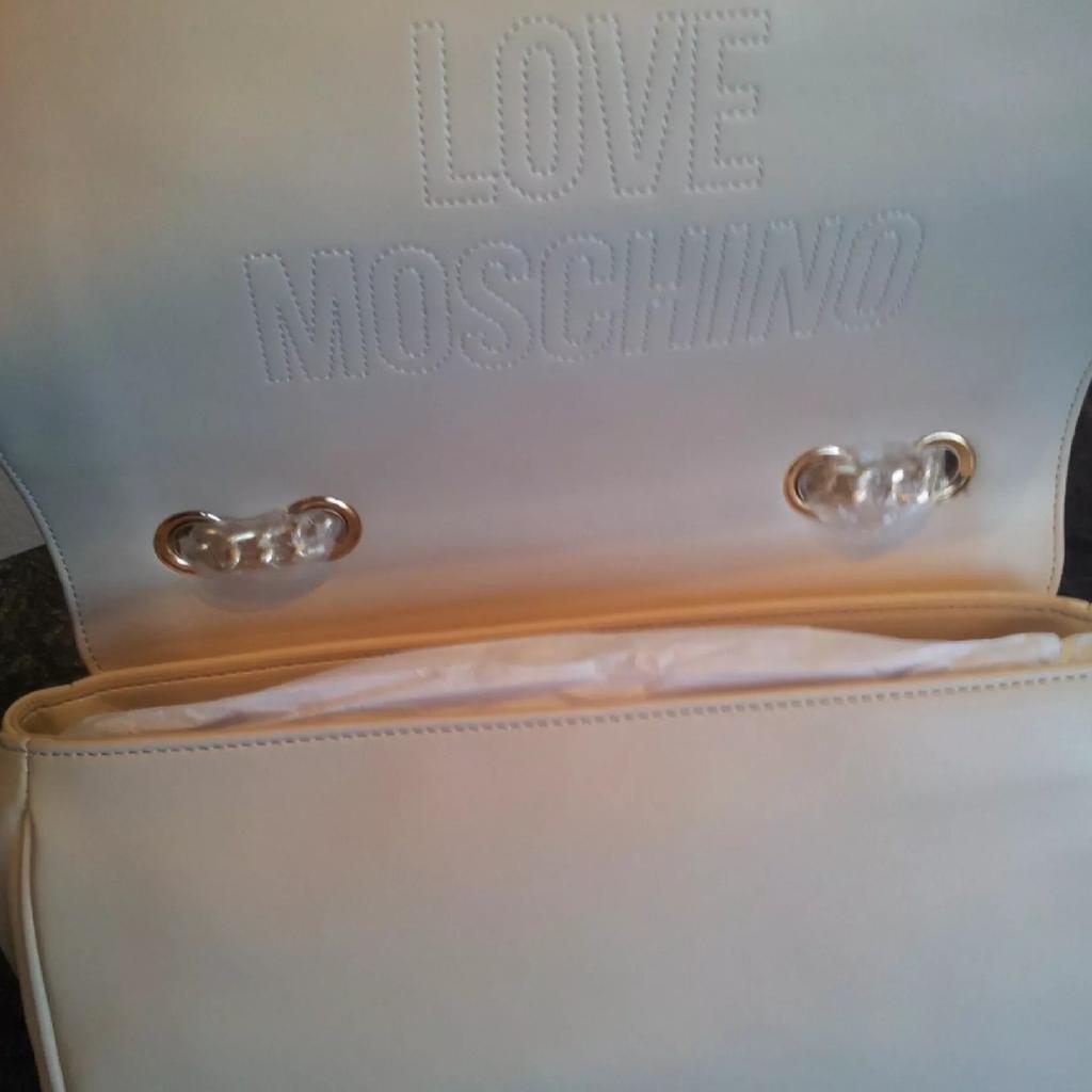 Schöne neue Love Moschino Tasche
Cremefarben mit goldfarbenen Details. Inklusive Staubbeutel.