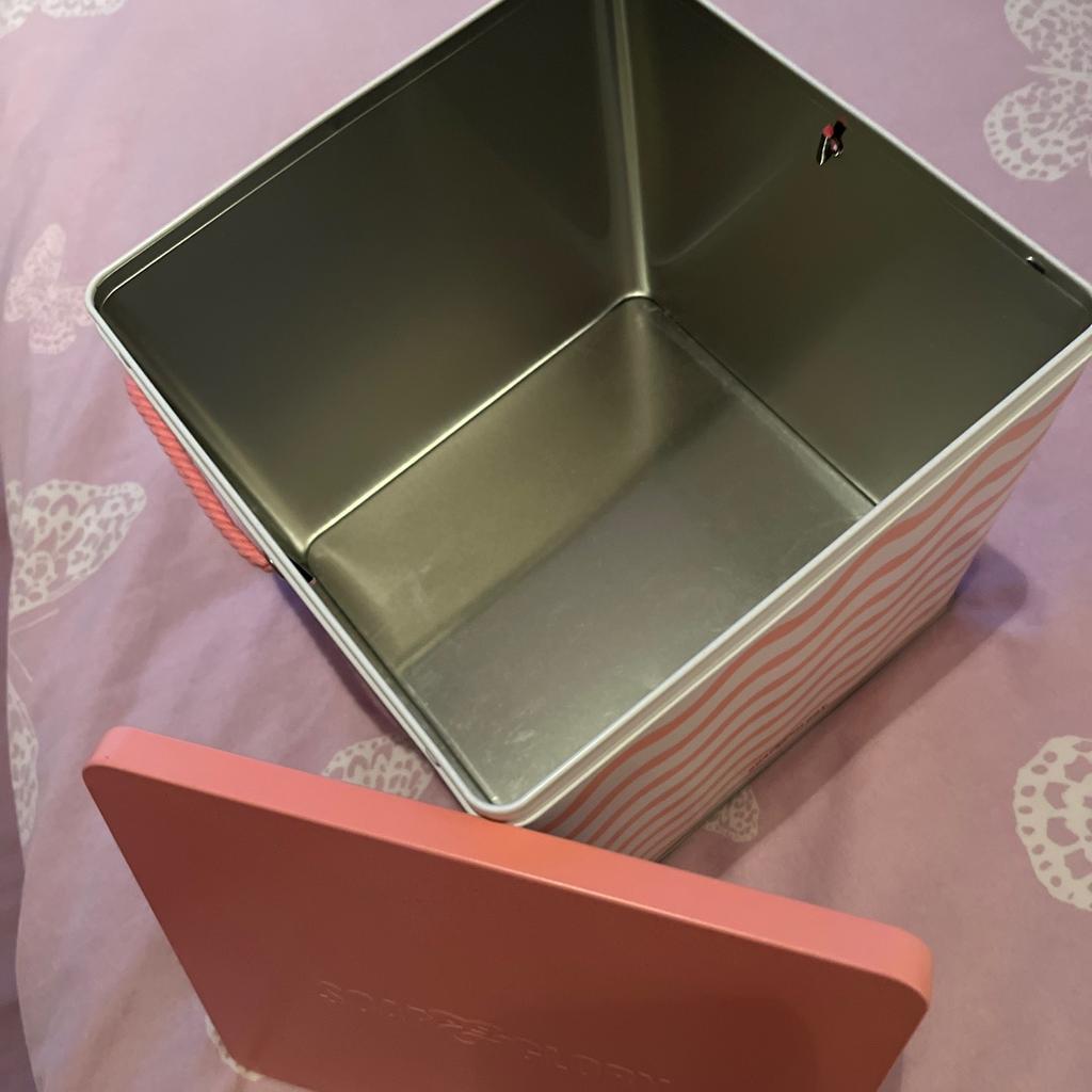 Peach/pink empty Soap & Glory gift tin, with rope handle, which can be filled and used for gifting. Can hold at least half a dozen full size toiletry items. Or can be used to store other toiletries or cosmetics.