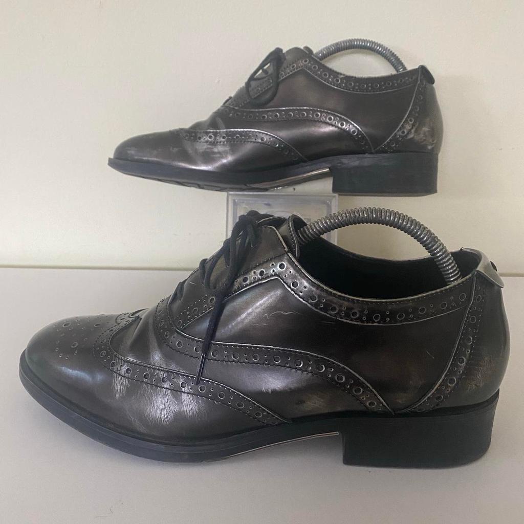 Dune London Women’s Shoes Farnley Lace Up Brogues Pewter Patent Leather Freeflex Soles
Shoe size UK 7 / US 9.5 / EU 41
Used in good condition
Please expect marks commensurate with being used, check photos for further details of condition.
(Shoes trees not included)
Invest in retro comfort with these Farnley Lace Up Brogues by Dune. Stylish and easy-to-wear, the design comes with traditional lacing, round toe and a low block heel. Wear with various types of trousers - from jeans to cigarette trousers.

Check out my other listings for more quality branded, vintage, retro and new clothing items.

Same working day despatch
Or cash on collection in person welcome from DA7.