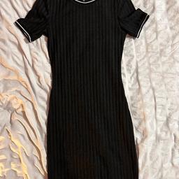 Schwarzes Kleid aus Polyester mit weißen Streifen am Hals und an den Ärmeln.