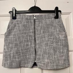 Black & white woven, fully lined miniskirt, featuring front zip and pockets, size 6 by Topshop. Worn a few times but still in good condition.