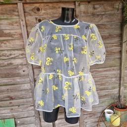 . Asos design size 14 tiered smock top. Sheer white organza with embroidered green and yellow flowers. Oversized fit. Short puff sleeves with gathered shoulders and edges. Open slit back with 2 ribbon ties. 
61% polyamide 
39% polyester
