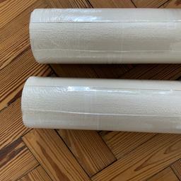 2 rolls of cream textured wallpaper, ideal for covering imperfect walls and for painting over. In addition, 3 decorative wallpaper boarder rolls.