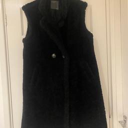 This is a lovely warm long gilet it has no sleeves it has side pockets & can be buttoned at the front or left open. Very warm & trendy. Had very minimum wear so in great condition. Is machine washable . Collection only or can deliver locally for fuel . SIZE 16/18/20 very generous size 16.