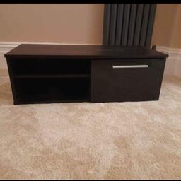 black TV stand, with a cupboard and a shelf.